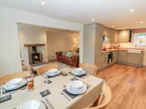 een keuken en een woonkamer met een tafel en stoelen bij Cobble Cottage in Keswick