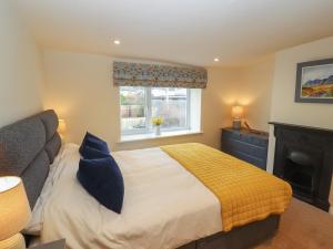 um quarto com uma cama, uma lareira e uma janela em Cobble Cottage em Keswick