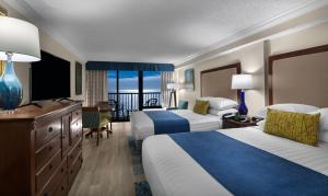 a hotel room with two beds and a balcony at Sea Crest Oceanfront Resort in Myrtle Beach