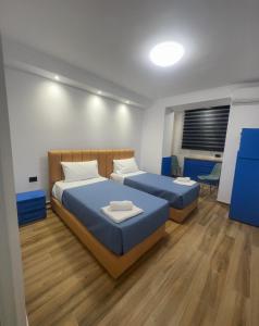 sypialnia z 2 łóżkami i niebieską pościelą w obiekcie Keli’s apartment w Tiranie