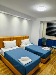 sypialnia z 2 łóżkami i niebieską pościelą w obiekcie Keli’s apartment w Tiranie