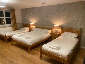 two twin beds in a room with two lamps at The Bullshead, Arthingworth House B&B in Market Harborough