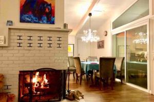 a dining room with a fireplace and a dining table at Black Bear Haven Hot tub Pool table BBQ Darts in Oakhurst