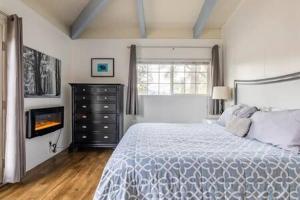 a white bedroom with a bed and a fireplace at Black Bear Haven Hot tub Pool table BBQ Darts in Oakhurst