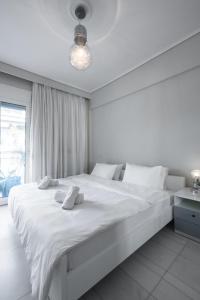a white bedroom with a large white bed with white pillows at #Luxlikehome Horizon Apartment Thessaloniki in Thessaloniki