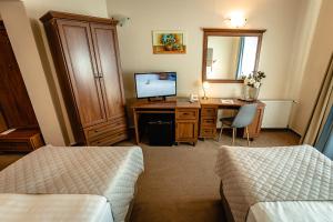 ein Hotelzimmer mit Schreibtisch und Fernseher in der Unterkunft Dixon Resort & Wellness in Banská Bystrica