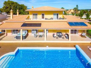 a villa with a swimming pool in front of a house at Villa Golden Bay by Algarve Vacation in Carvoeiro