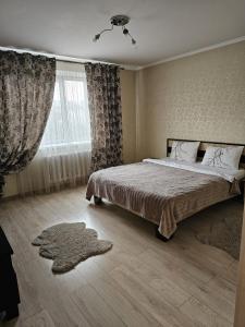 ein Schlafzimmer mit einem Bett und einem großen Fenster in der Unterkunft Decebal 2 in Chişinău