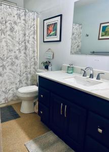 a bathroom with a sink and a toilet and a mirror at My Ohana - 30 days in Kailua-Kona