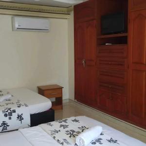 - une chambre avec deux lits et une commode avec une télévision dans l'établissement Comfortable apartmento frente al mar, A/C / POOL, à Carthagène des Indes