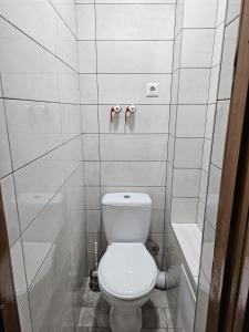 ein weißes Bad mit einem WC und einer Badewanne in der Unterkunft Decebal 2 in Chişinău