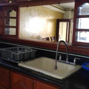 - un comptoir de cuisine avec un évier et un miroir dans l'établissement Comfortable apartmento frente al mar, A/C / POOL, à Carthagène des Indes