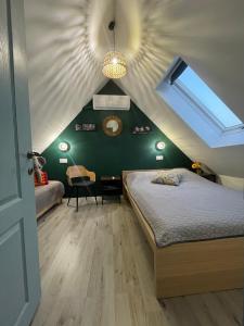 Schlafzimmer im Dachgeschoss mit einem Bett und einem Dachfenster in der Unterkunft IstEni 2 Zamárdi akár 8-10 fő in Zamárdi