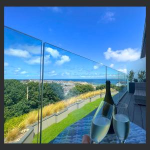 a person holding two glasses of wine on a balcony at Uno - St Ives in St Ives