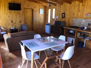 a kitchen and living room with a table and chairs at Los Alamos in Plottier
