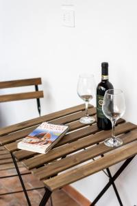 una mesa de madera con 2 copas y una botella de vino en Flat Terrace The Moon over Florence, en Florencia
