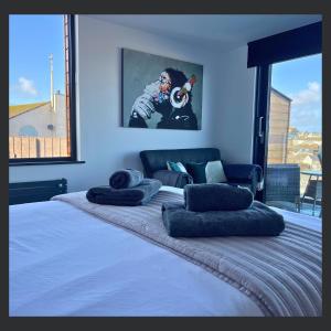 a bedroom with a large bed with pillows on it at Uno St Ives - Luxury Serviced Accommodation in St Ives