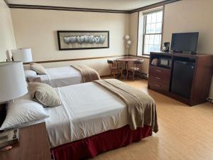 um quarto de hotel com duas camas e uma mesa em Fenway House Hotel em Fennimore