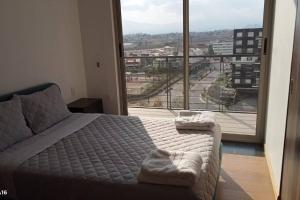 a bedroom with a bed and a large window at Departamento nuevo en High Towers Elite, Sonata in Lomas de Angelopolis