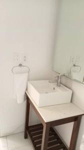 a white bathroom with a sink and a mirror at Departamento nuevo en High Towers Elite, Sonata in Lomas de Angelopolis