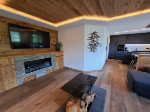 ein Wohnzimmer mit einem Kamin und einem TV in der Unterkunft Nature luxury Chalet INSToul in Luttach