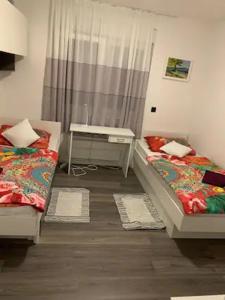 a room with two beds and a table in it at RioDia Seaview Stay in Primošten