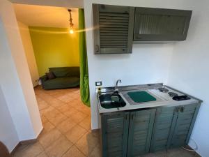 cocina con fregadero y cocina con sofá en VIKY apartments, en Buonfornello