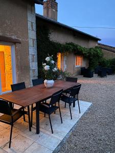 La Fermette Aux Canards في Savigny-Lévescault: طاولة وكراسي خشبية أمام المنزل