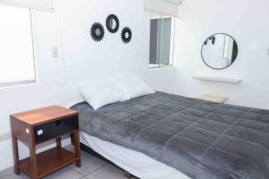 a bedroom with a bed and a mirror and a table at Apartamento D&D Huanchaco in Huanchaco