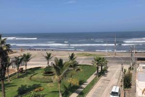 a view of a beach with palm trees and the ocean at Apartamento D&D Huanchaco in Huanchaco