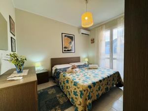 a bedroom with a bed with a teddy bear on it at Casa vacanza "Orchidea" in Marzamemi