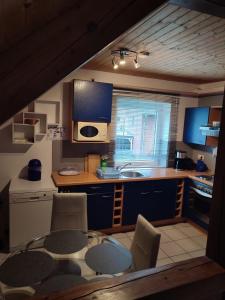eine Küche mit einem Tisch, Stühlen und einer Mikrowelle in der Unterkunft Wohnung Auerand in Nienhagen