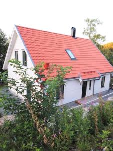 ein kleines weißes Haus mit orangefarbenem Dach in der Unterkunft Hus precis intill sjö in Lindome