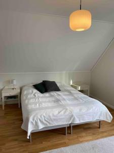 a white bedroom with a large white bed in it at Hus precis intill sjö in Lindome