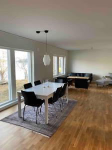 a dining room with a white table and chairs at Hus precis intill sjö in Lindome