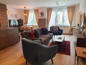 - un salon avec un canapé, des chaises et une table dans l'établissement Apartman guru 1, à Szeged