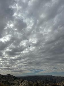 um céu nublado sobre um desfiladeiro com uma montanha em Orion's wild camp em Dana