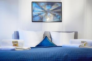 ノイシュタット・アン・デア・ヴァインシュトラーセにあるIDEE Living Industrial style- Apartment- Balkonの青いベッド(白い枕付)が備わります。
