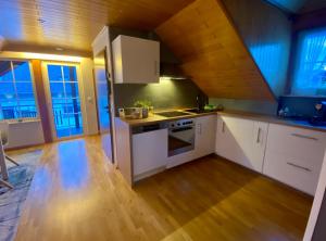 cocina con armarios blancos y suelo de madera en Fewo-zum-Nussbaum - Mosel 2, en Schweich