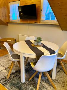 mesa de comedor y sillas con mesa y TV en Fewo-zum-Nussbaum - Mosel 2, en Schweich