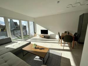 ein Wohnzimmer mit einem Sofa und einem Tisch in der Unterkunft 3 ZW 95 m2 Neubau Kostenlos Parkplatz im Hof in Kitzingen