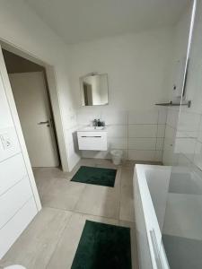 La salle de bains est pourvue d'une baignoire, d'un lavabo et de toilettes. dans l'établissement 3 ZW 95 m2 Neubau Kostenlos Parkplatz im Hof, à Kitzingen