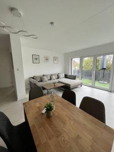 ein Wohnzimmer mit einem Tisch und einem Sofa in der Unterkunft 3 ZW 95 m2 Neubau Kostenlos Parkplatz im Hof in Kitzingen