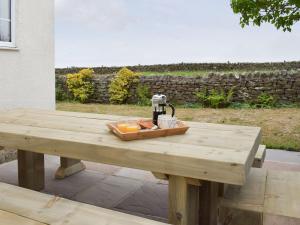a wooden picnic table with a coffee maker on it at Rudda Farm Cottage - Uk2492 in Staintondale
