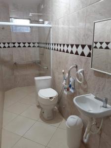 a bathroom with a toilet and a sink at Sonho dos golfinhos in Recife