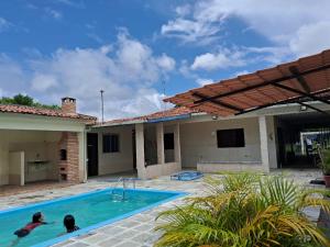 two people in a swimming pool in a house at Sonho dos golfinhos in Recife