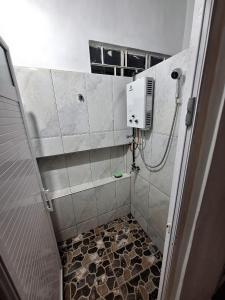 a bathroom with a shower with a tiled floor at SB Villa in Triolet