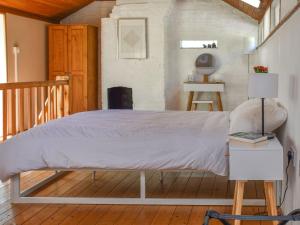 a bedroom with a large bed with a wooden floor at Hollybush Studio - Uk39054 in Knebworth