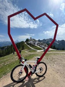 a bike with a heart shaped frame on a hill at Mountain Apartment Rododendro in Tarvisio