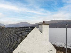 a roof of a house next to a body of water at Lochside Apartment in Inveraray